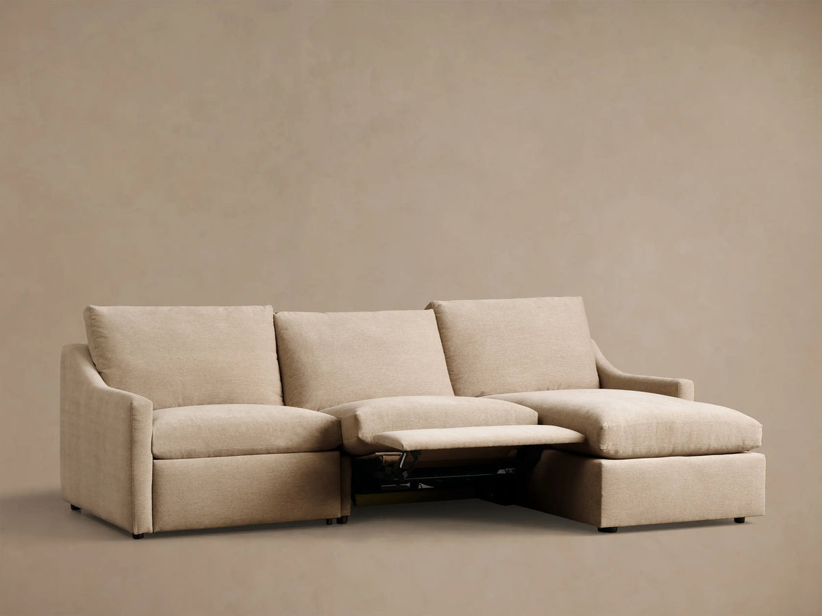 Light beige Kipton Slope Arm Three-Piece Motion Chaise Sectional with the motion footrest extended.
