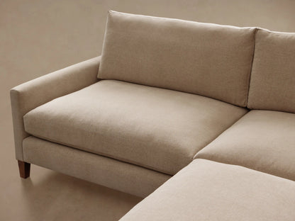 Front view of a light beige Kipton Slim Arm Elevated Two-Piece Sectional with slim arms and mocha-finished feet.