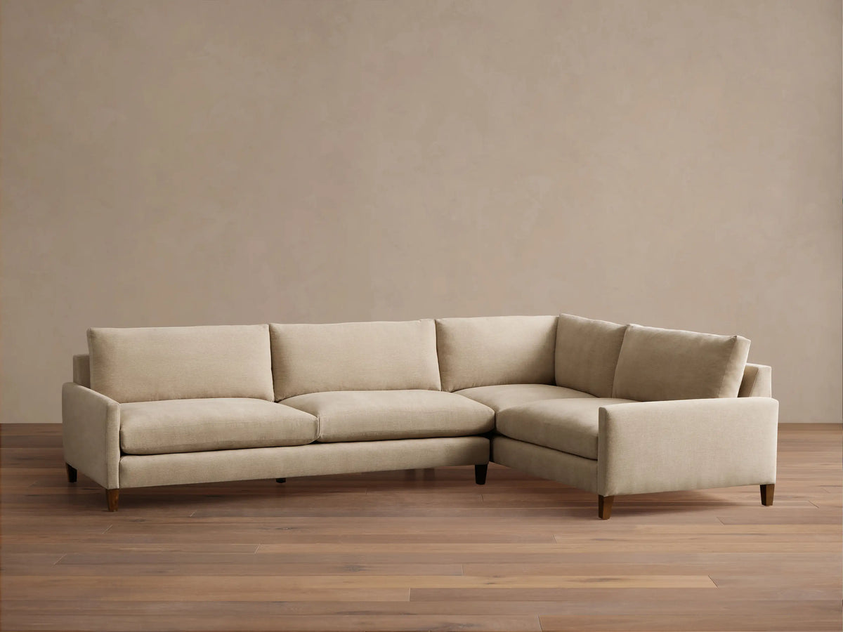 Front view of a light beige Kipton Slim Arm Elevated Two-Piece Sectional with slim arms and mocha finish wooden feet.