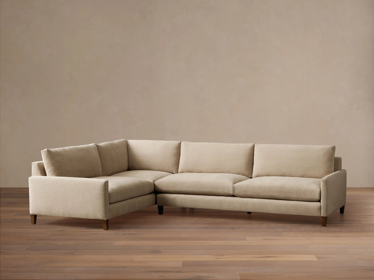 Front view of a beige Kipton Slim Arm Elevated Two-Piece Sectional with slim arms and elevated mocha finish feet.