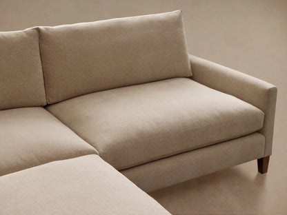 Front view of the beige Kipton Slim Arm Elevated Two-Piece Sectional, featuring slim arms and dark mocha finish legs.