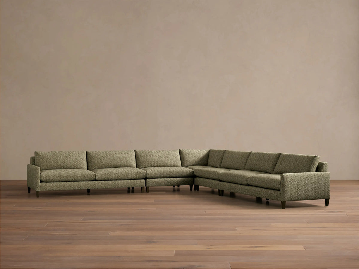 Front view of the green patterned Kipton Slim Arm Elevated Five-Piece Corner Sectional with slim arms and mocha finished elevated feet.