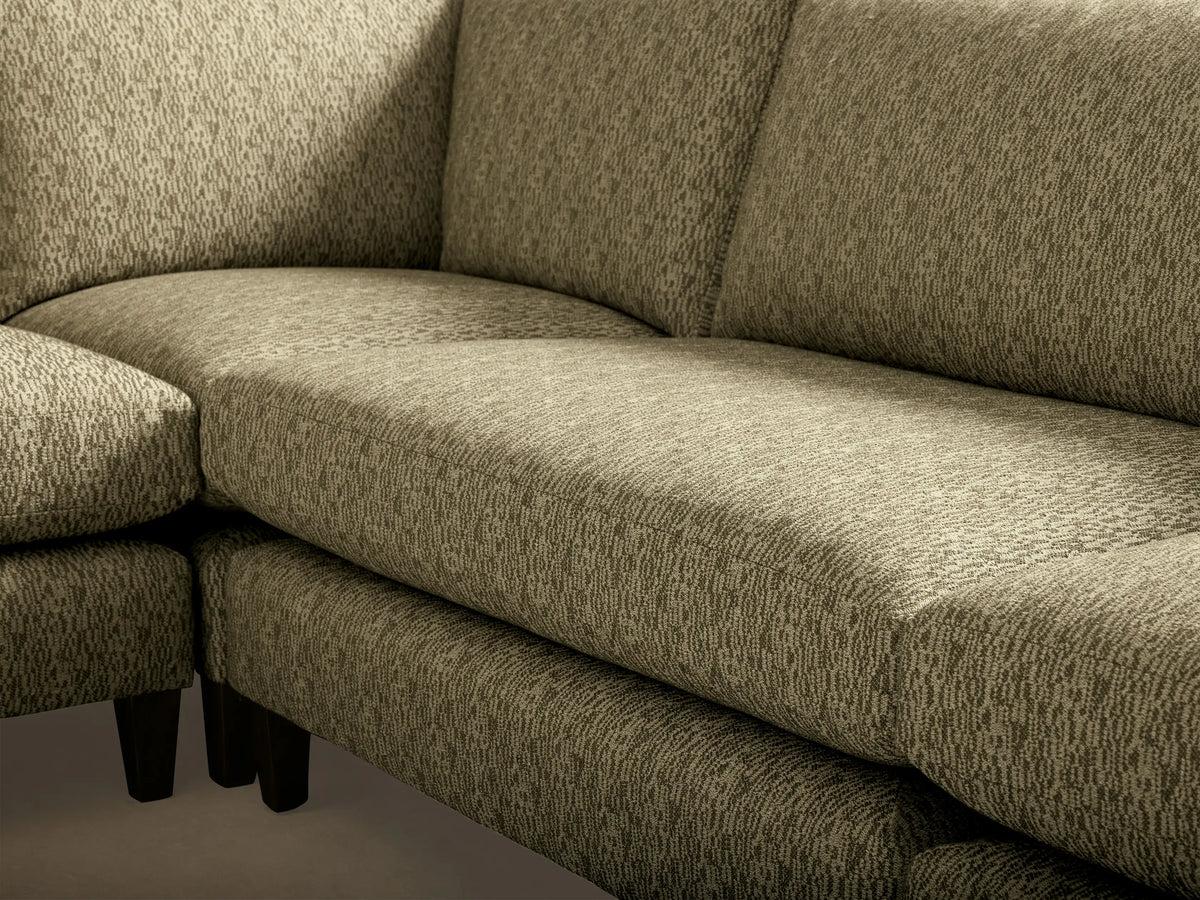 Rear view of the light green patterned fabric Kipton Slim Arm Elevated Five-Piece Corner Sectional with mocha finish feet.