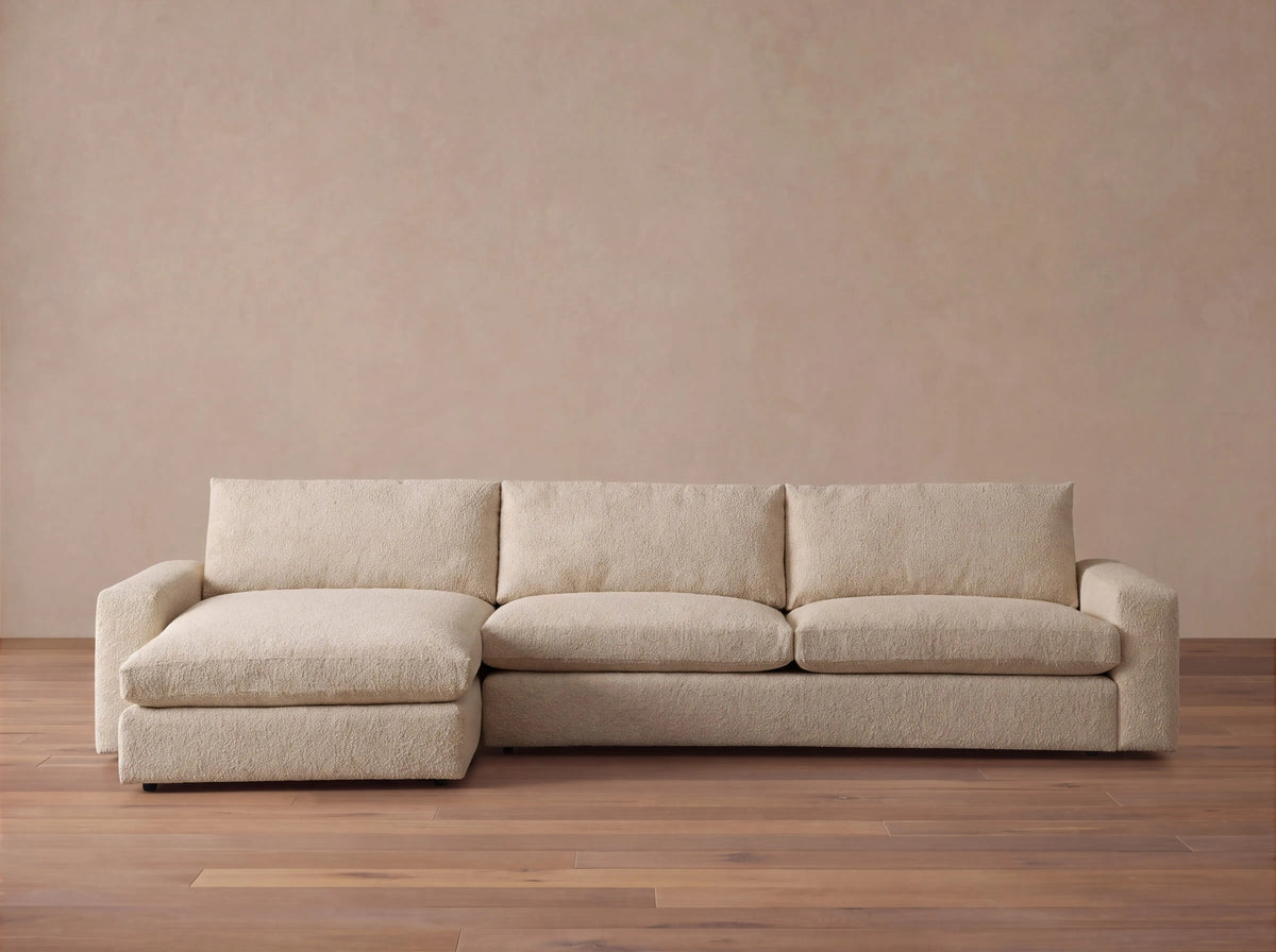 Kipton Wide Arm Two-Piece Chaise Sectional in light beige fabric, L-shaped, with chaise lounge on the left.