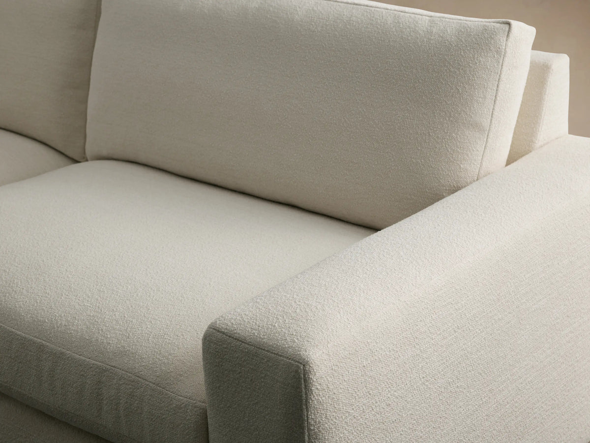 Kipton Wide Arm Sofa, off-white textured fabric, 2 seat/back cushions, wide square arms, on a wooden floor.