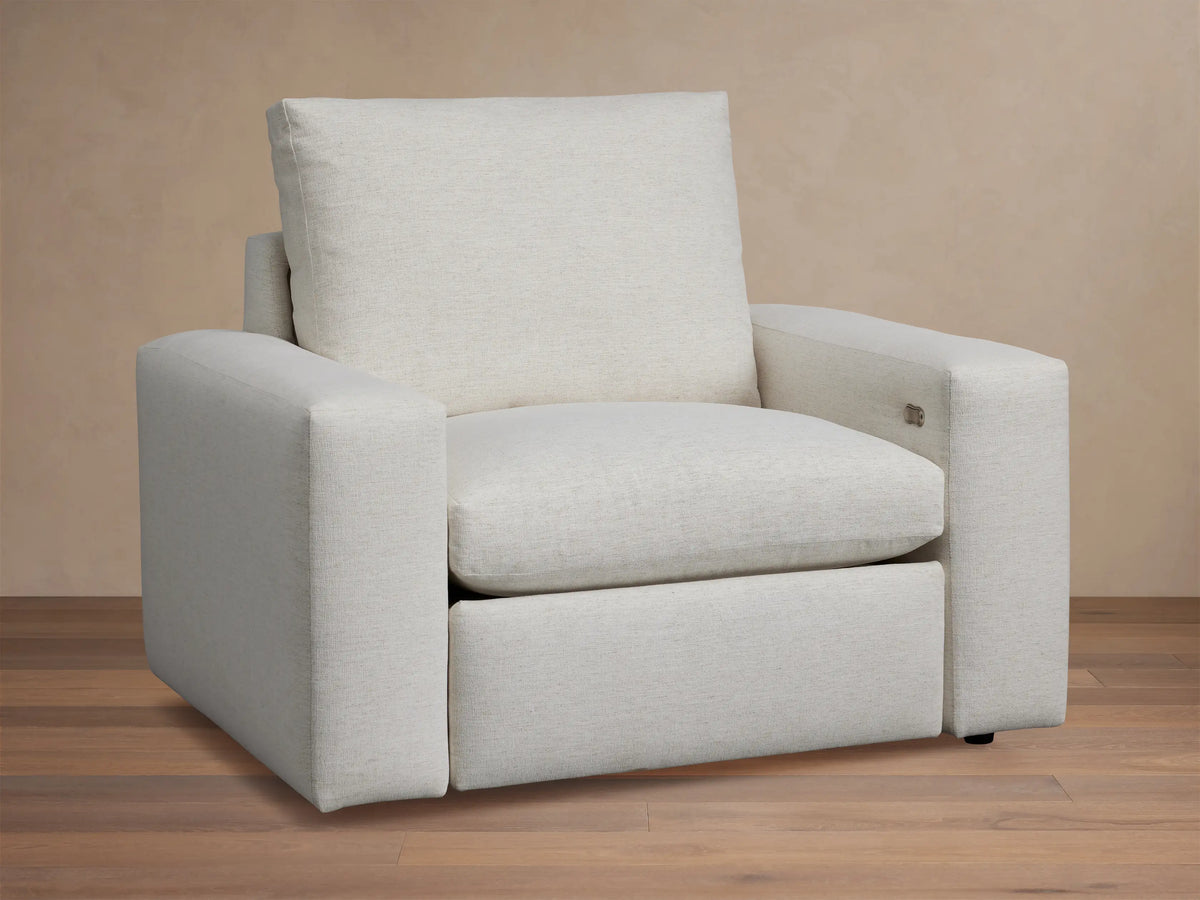 Kipton Wide Arm Motion Recliner, light beige upholstered fabric, front view. Wide arms & plush cushions. Power controls on arm.