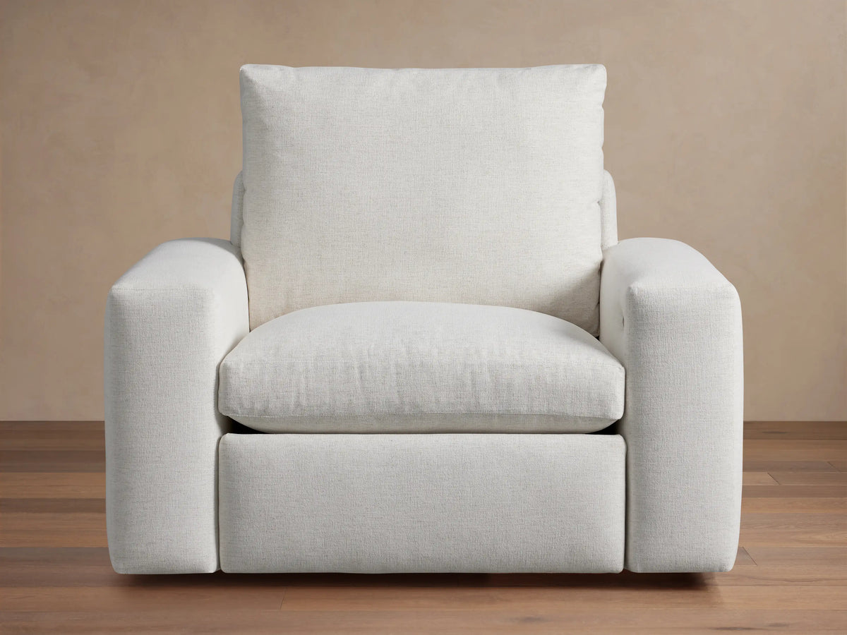 Kipton Wide Arm Motion Recliner, light beige upholstered fabric, front view. Wide arms & plush cushions. Power controls on arm.