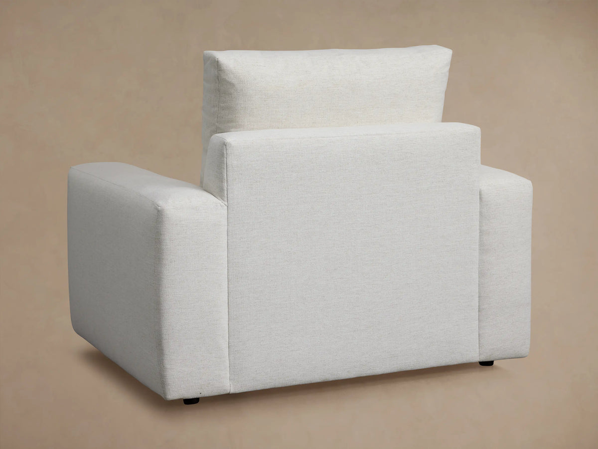 Close-up of Kipton Wide Arm Motion Recliner. Light beige textured fabric on wide arm and seat, with a sleek silver power button.