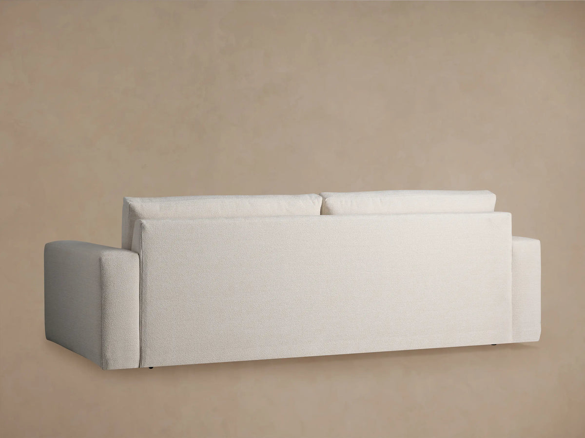 Kipton Wide Arm Sofa, angled close-up. Light cream, textured fabric on wide arm, seat, and back cushion.