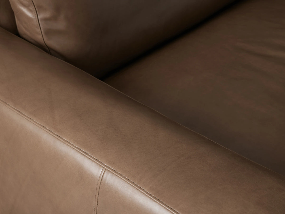 Kipton Wide Arm Leather Sofa, a modern, brown leather 2-seater with wide square arms, two seat cushions, and two back cushions.