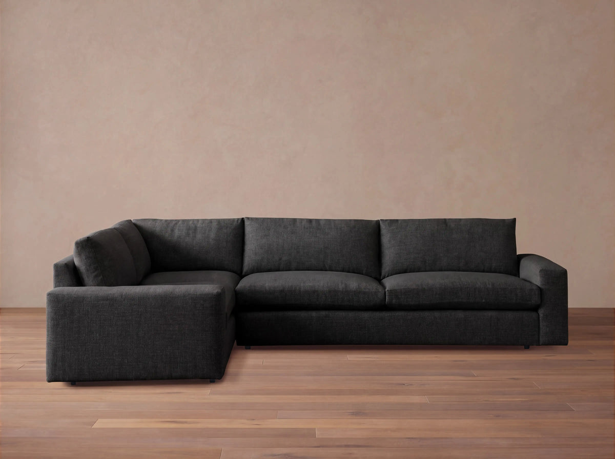 Front view of a dark grey Kipton Wide Arm Two-Piece Sectional with a wide arm and chaise lounge on the left.