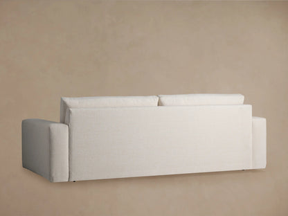 Close-up of the Kipton Wide Arm Sofa, showing the wide arm, seat cushion, and back cushion in textured light beige fabric.