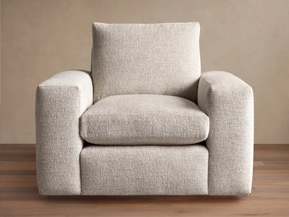 Kipton Wide Arm Swivel Chair. Modern, light beige textured fabric with wide square arms and plush cushions, angled right.