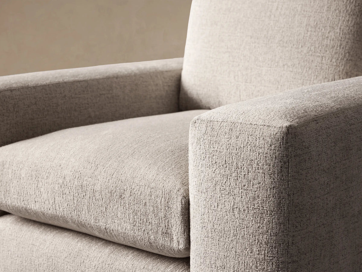 Light beige Kipton Wide Arm Swivel Chair with textured fabric, wide squared arms, and plump cushions, front view on wood floor.