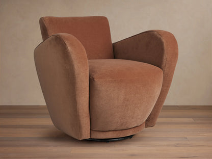 Front-right view of a plush, curved, rust-colored velvet Amelia Swivel Chair on a black swivel base, set on a wooden floor.