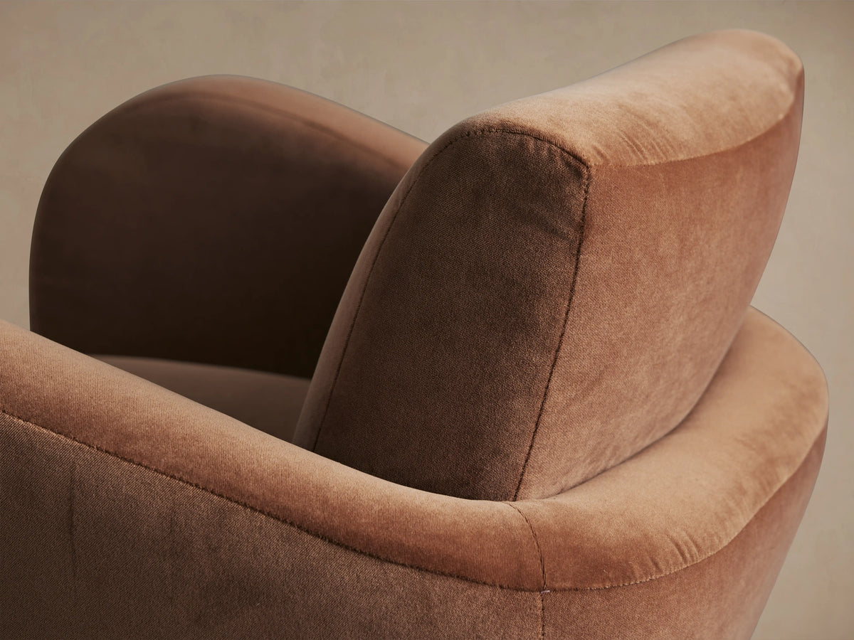 Amelia Swivel Chair, rust-colored upholstered modern design with rounded arms and a visible black swivel base, front view.