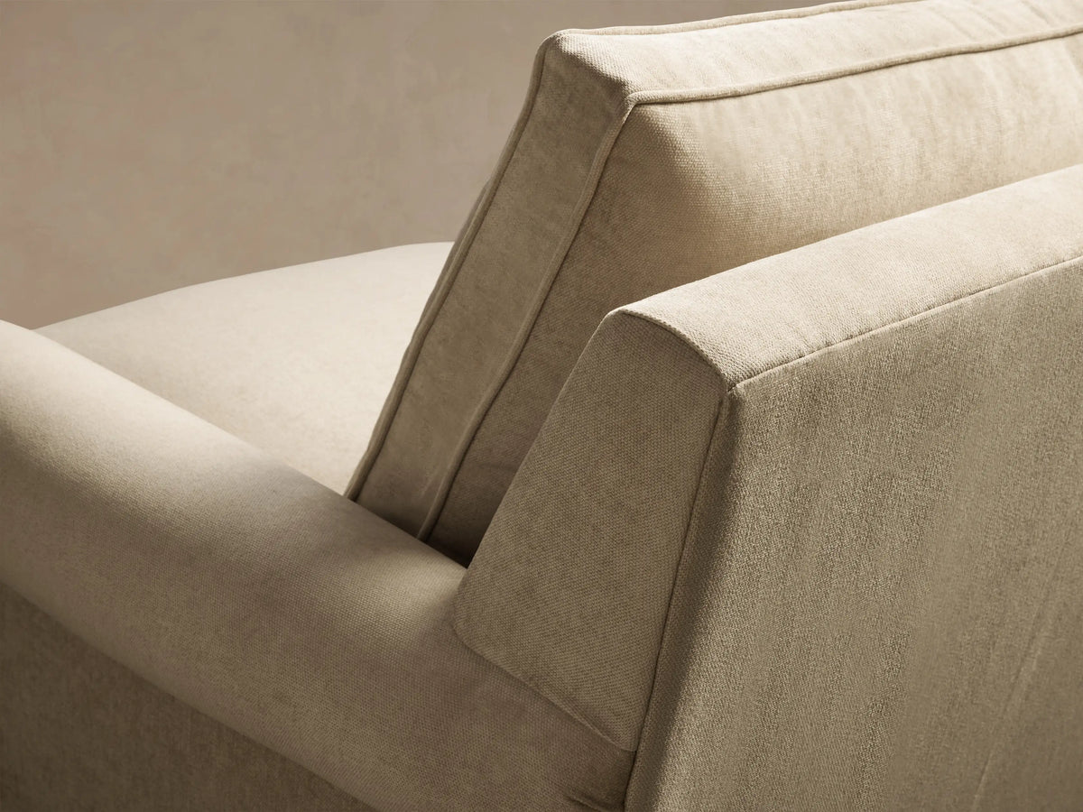 Front view of the light beige McKinley Chair with Fringe, featuring rolled arms, a plump back cushion, and fringe skirt.