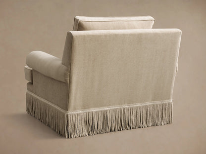 Close-up of the beige McKinley Chair with Fringe, highlighting rolled arms, a piped seat cushion, and a long fringe trim.