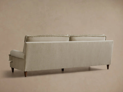 Front view of the Natural beige McKinley Sofa, a two-seater with fringed trim on its cushions, arms, and back, featuring rolled arms.