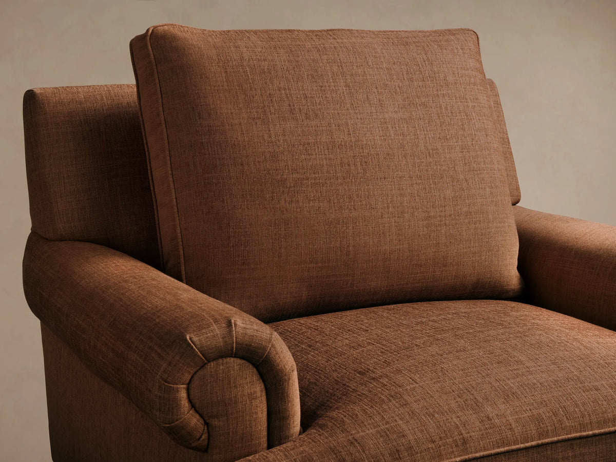 Close-up of the textured brown McKinley Chair with Fringe, showing a rolled armrest, seat cushion, and braided fringe skirt.