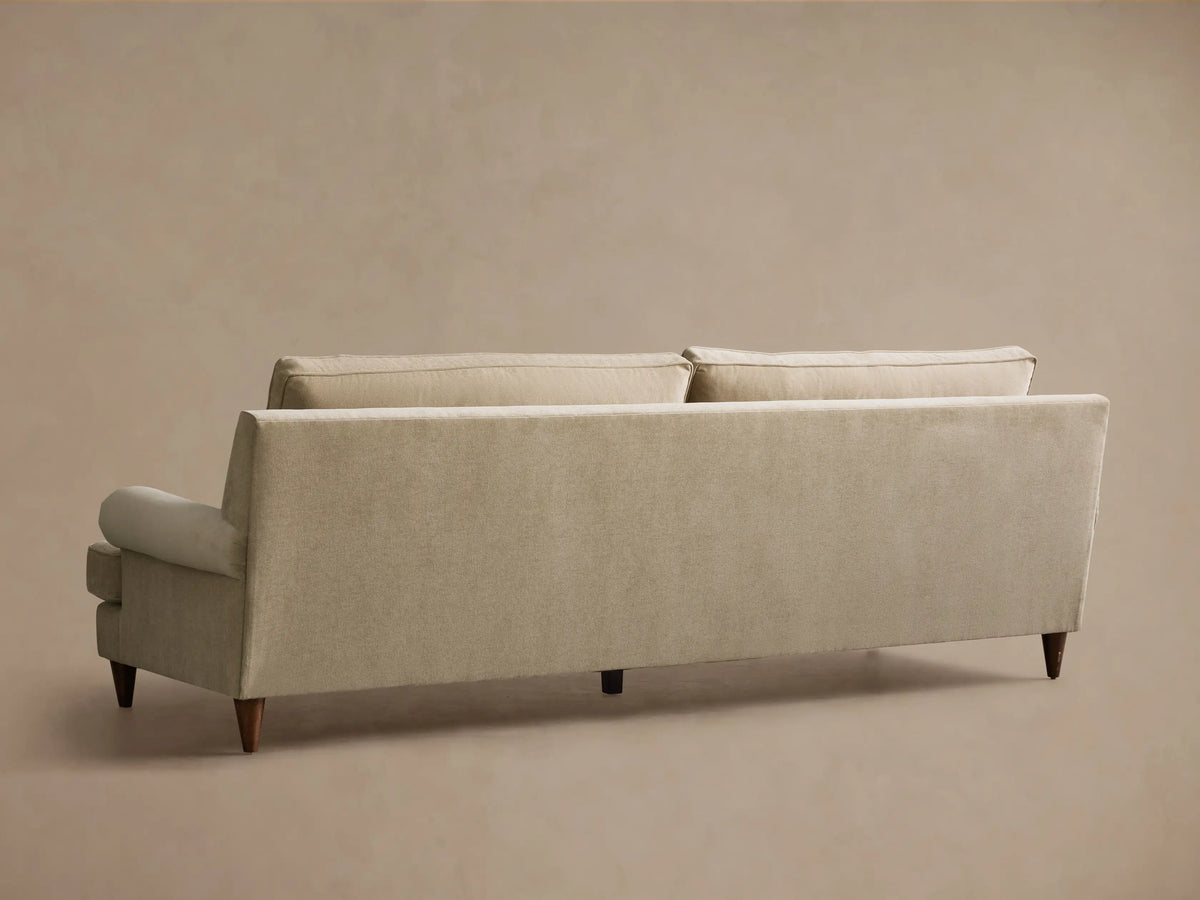 Front view of the oatmeal McKinley Sofa, featuring two large seat cushions, two plush back cushions, rolled arms, and dark wooden legs.