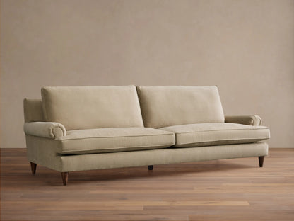 Rear three-quarter view of the light beige McKinley Sofa, showing its upholstered back, two back cushions, and tapered wooden legs.