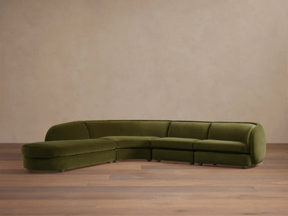 Olive green Milana Four-Piece Bumper Sectional on wooden floor, featuring armless chair, corner wedge, and arm chairs in a crescent shape.