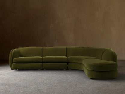 Olive green Milana Four-Piece Bumper Sectional on wooden floor, featuring armless chair, corner wedge, and arm chairs in a crescent shape.