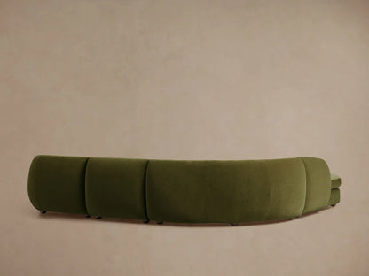 Milana sectional in olive-green fabric, showcasing a curved, plush design with deep cushioning against a neutral background.
