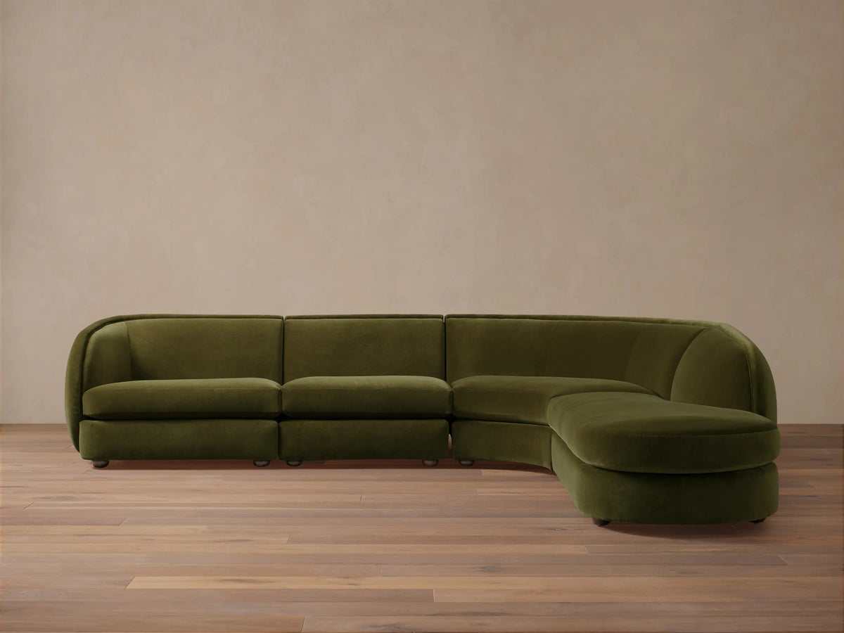Milana Four-Piece Bumper Sectional in dark green fabric, featuring curved design with right-side bumper, on wooden floor.