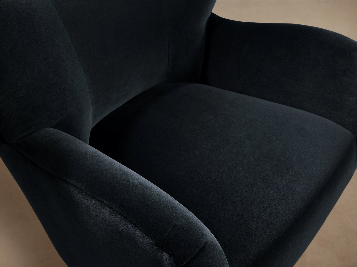 Front view of the Navy Myra Chair, an upholstered armchair with a high winged back, wide arms, and dark tapered wooden legs.