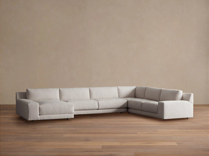 Light beige Novoli Four-Piece Chaise Sectional with left chaise and ribbed right arm, on a wood floor against a plain wall.