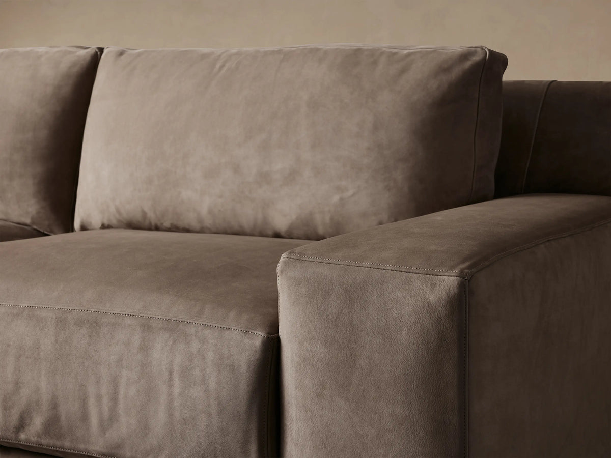 Novoli Nubuck Leather Two-Piece Chaise Sectional, L-shaped, in warm taupe, with a left-facing chaise, on light wood.
