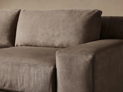 Novoli Nubuck Leather Two-Piece Chaise Sectional, L-shaped, in warm taupe, with a left-facing chaise, on light wood.