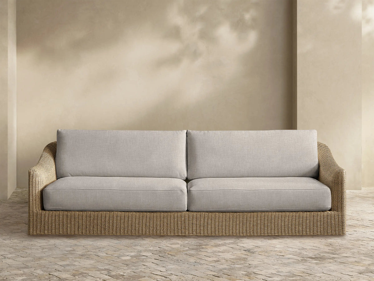 Front view of the Ancona Outdoor Sofa with light gray cushions and a natural-toned all-weather woven wicker frame.
