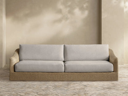 Front view of the Ancona Outdoor Sofa with light gray cushions and a natural-toned all-weather woven wicker frame.