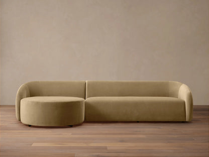 Modern, rounded light brown velvet Fresno Two-Piece Chaise Sectional with attached round chaise, on wood floor.