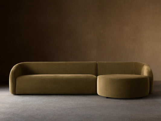Modern, rounded light brown velvet Fresno Two-Piece Chaise Sectional with attached round chaise, on wood floor.