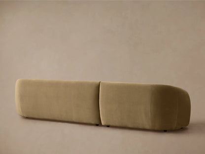 Close-up, angled view of the curved back and arm of a plush, muted tan Fresno Two-Piece Chaise Sectional.