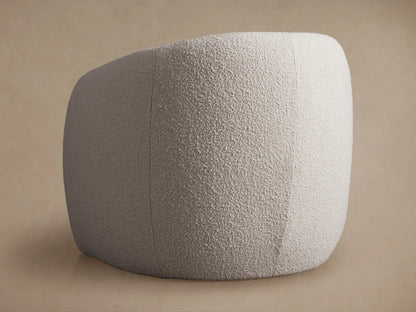 Close-up of a rounded, cream bouclv© Fresno Floating Seat Chair with a distinct floating seat design against a beige wall.
