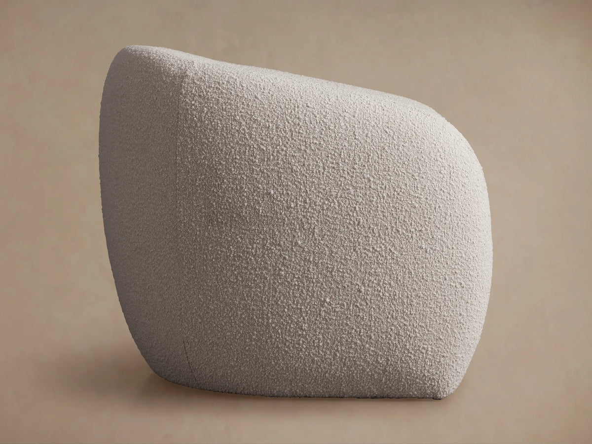 Fresno Floating Seat Chair: Cream, textured boucle fabric, rounded organic shape. Viewed from an elevated side angle on a neutral background.