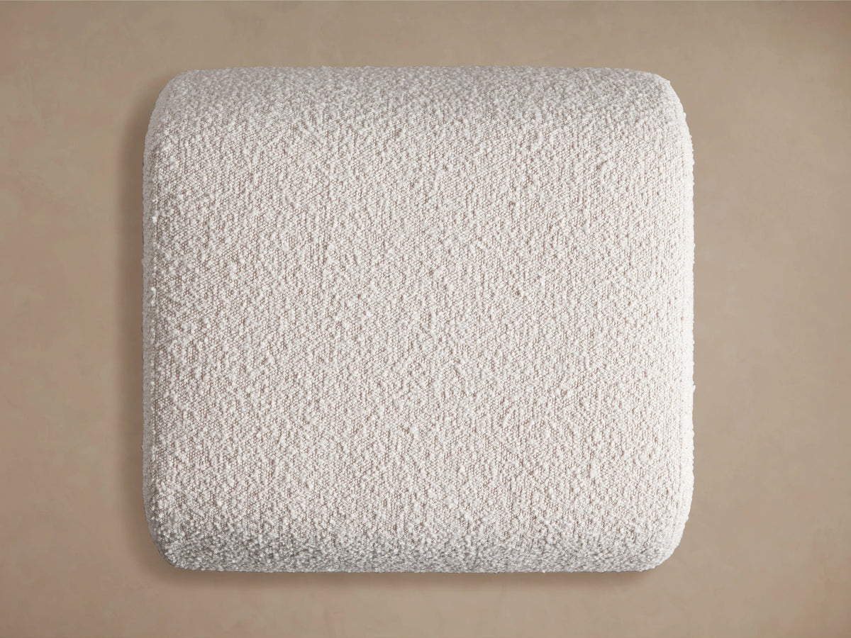 Fresno Ottoman with textured light gray fabric, showcasing a smooth, rounded corner against a soft beige background.