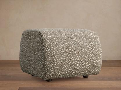 Front view of the Fresno Ottoman, a cube-shaped pouffe with a woven checkered pattern in light beige, brown, and grey.