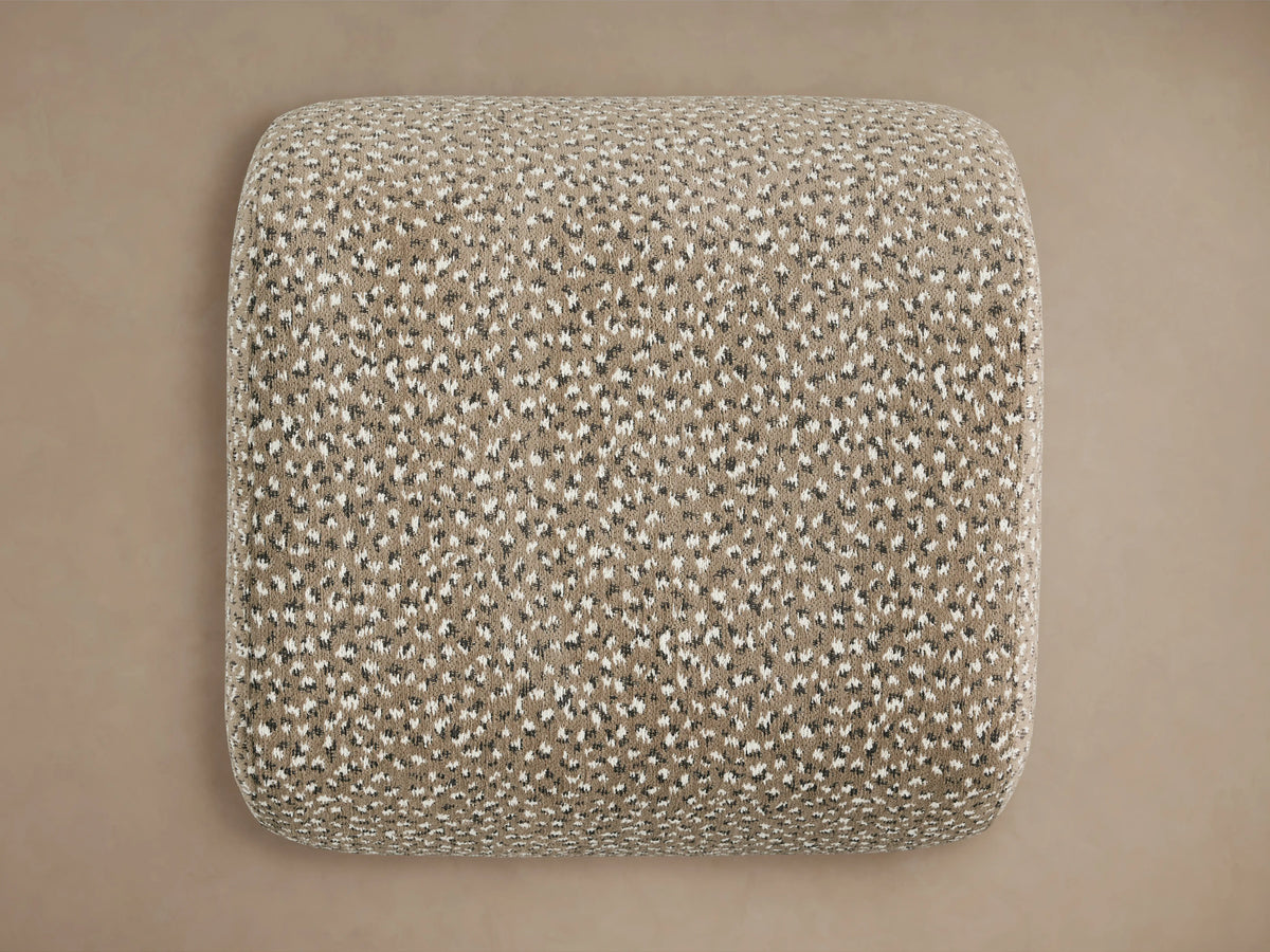 Fresno Ottoman with textured fabric in a speckled pattern of beige and cream tones, showing a close-up of the corner.