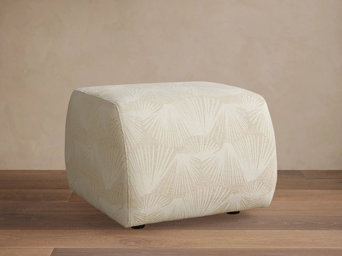 Front view of the Fresno Ottoman, featuring a woven checkered pattern in shades of beige and brown, in a bedroom.