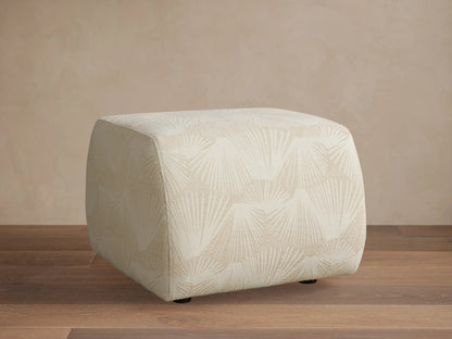 Front view of the Fresno Ottoman, featuring a woven checkered pattern in shades of beige and brown, in a bedroom.