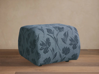 Front view of the cube-shaped Fresno Ottoman with a beige, gray, and brown checkered woven pattern.
