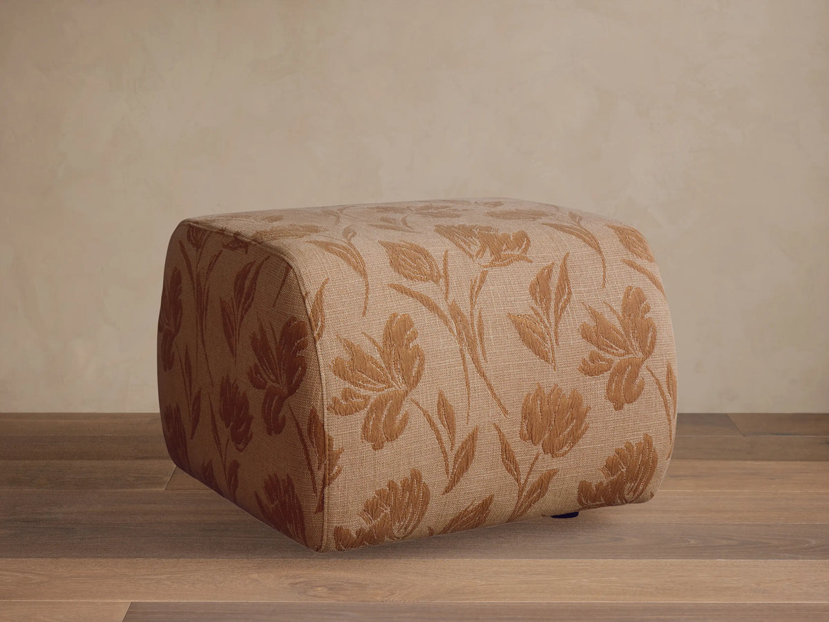Front view of the Fresno Ottoman, a rectangular woven ottoman with a geometric pattern in beige, light brown, and dark brown.
