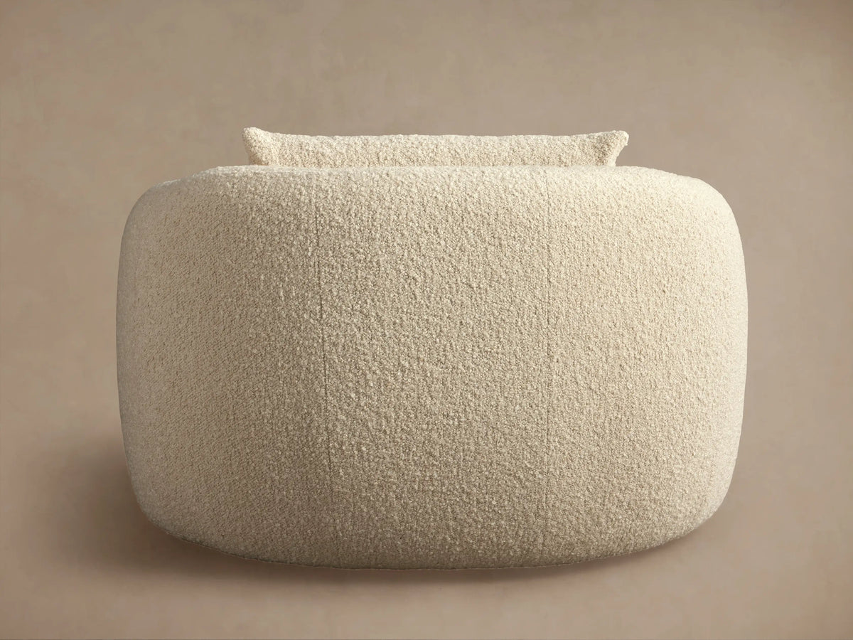 Fresno Oversized Swivel Chair in beige fabric, shown from the back, highlighting its curved, plush design on a neutral background.