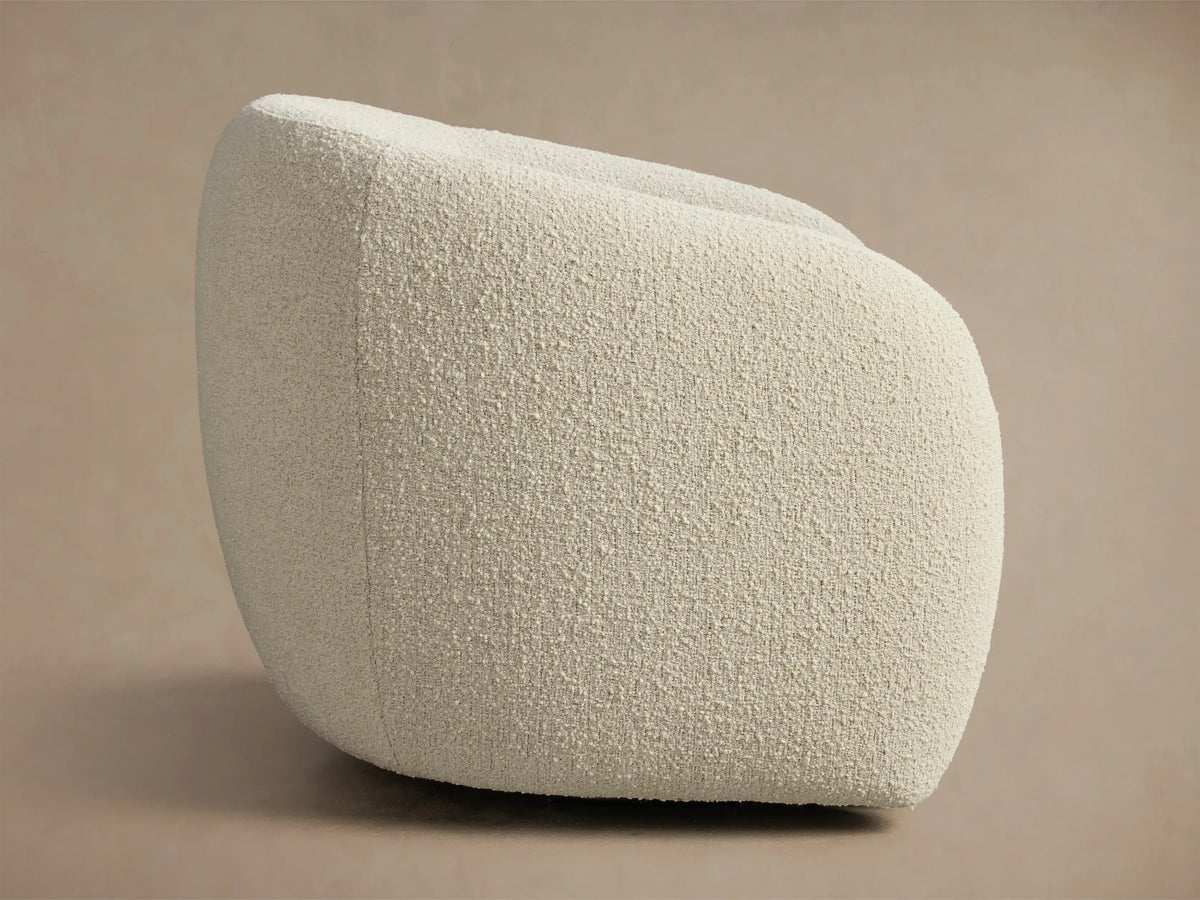 Side profile of a cream bouclé Fresno Swivel Glider, showcasing its rounded, contemporary design.